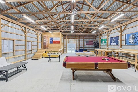 A billiards room with a pool table and flags on the wall.