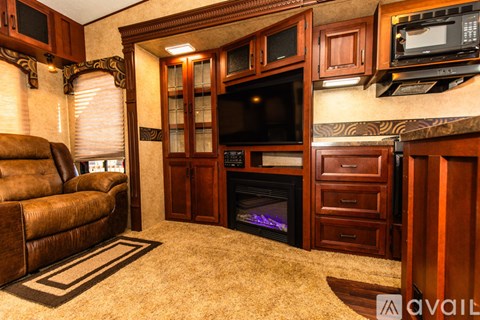 A living room with a brown couch and a fireplace.