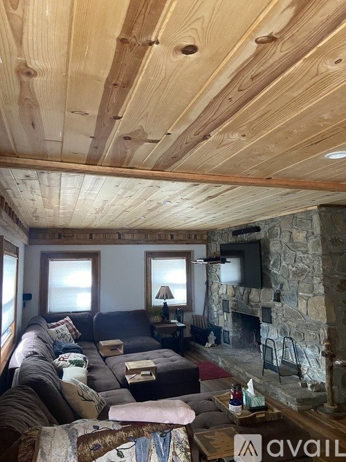 A living room with a stone fireplace and a couch.