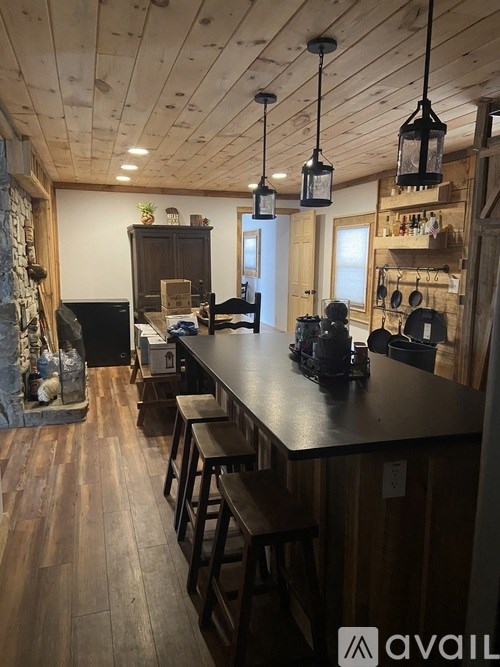A kitchen with wooden floors and a long bar.
