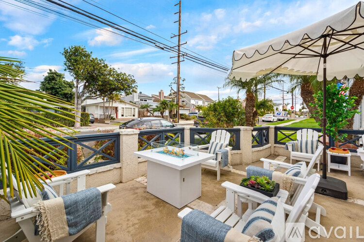 A patio with white furniture and a blue and white striped cushion.