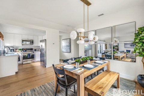 A modern dining room with a wooden table and chairs.