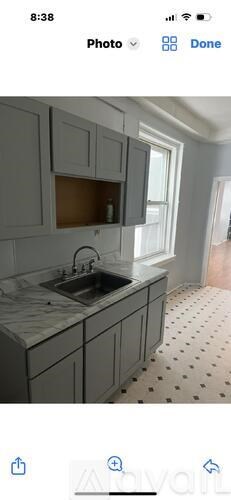 A kitchen with grey cabinets and a sink.