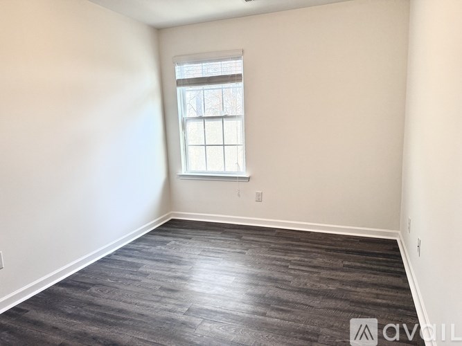 A room with a window and wooden flooring.