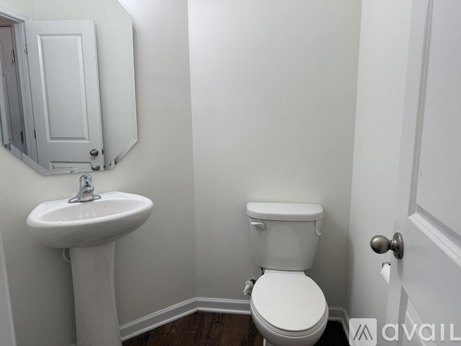 A white toilet sits next to a sink in a small bathroom.