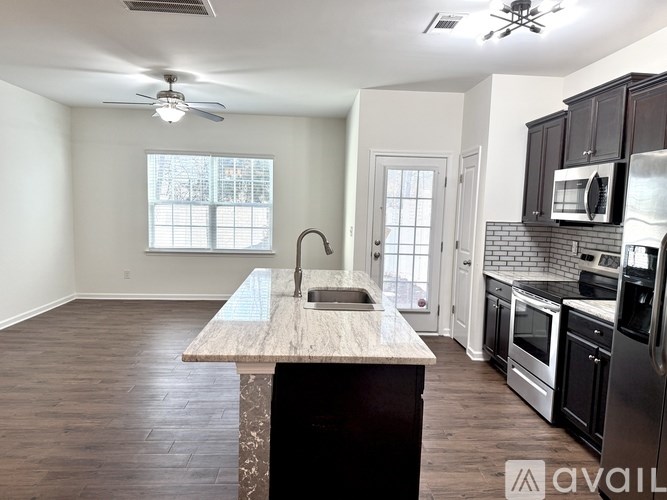 A kitchen with a wooden island and stainless steel appliances.