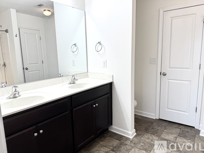 A bathroom with a white sink and a mirror above it.