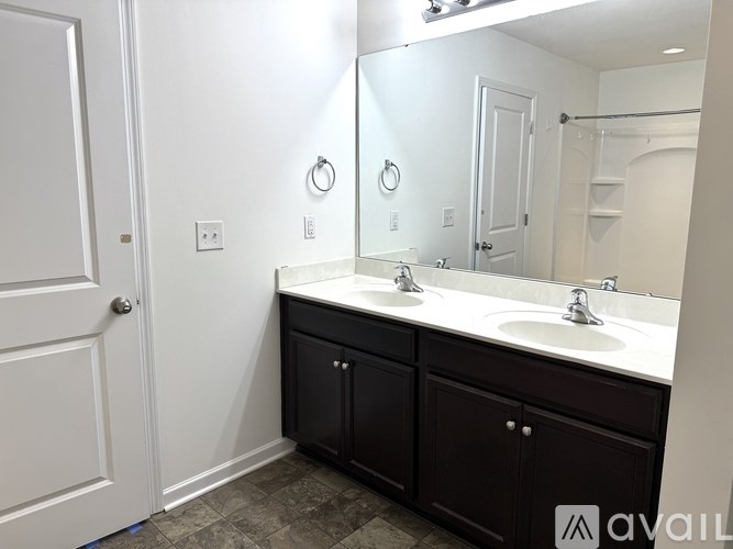 A bathroom with a white door, a white sink, and a mirror.