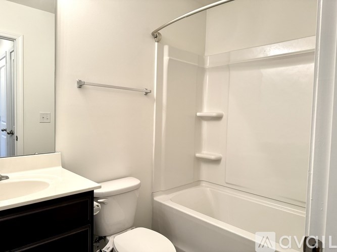 A white bathroom with a toilet, sink, and bathtub.