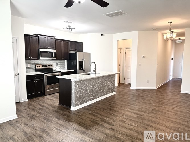 A kitchen with dark brown cabinets and a white island.