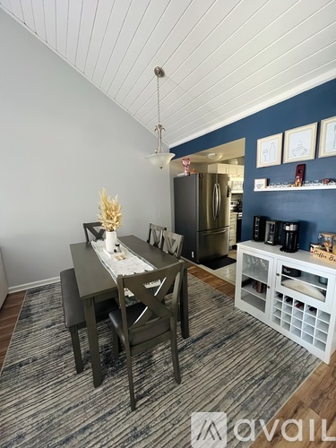 A dining area with a table set for two and a kitchen area in the background.