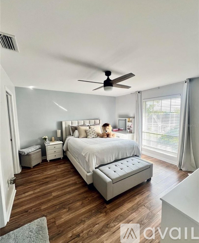 A bedroom with a large bed and a ceiling fan.