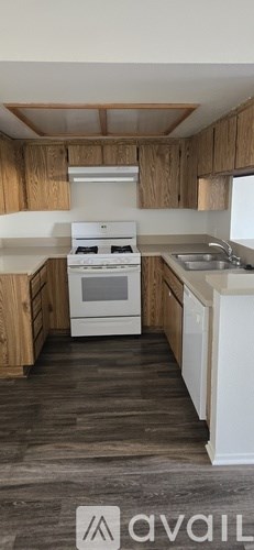 A kitchen with wooden cabinets and a white stove top oven.