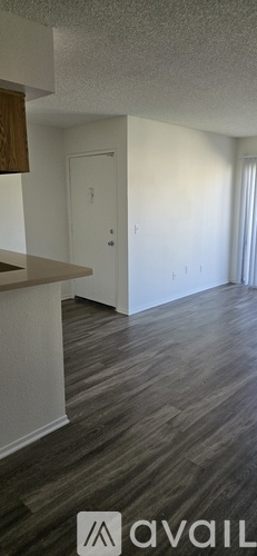 A room with wooden flooring and white walls.