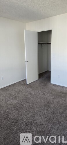 A room with a carpeted floor and a white door.