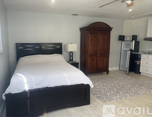A bedroom with a bed, dresser, and a cabinet.