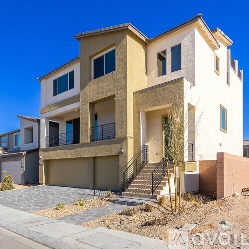 A modern two-story house with a balcony on the second floor.