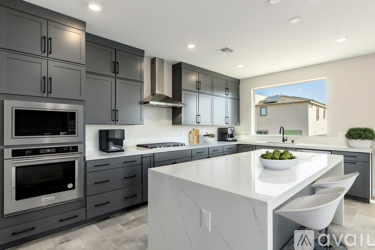 A modern kitchen with a large island and stainless steel appliances.