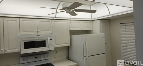 A kitchen with a white refrigerator and a white microwave oven.