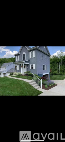A two-story house with a front porch and a metal railing.