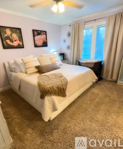 A bedroom with a bed, pillows, and a ceiling fan.