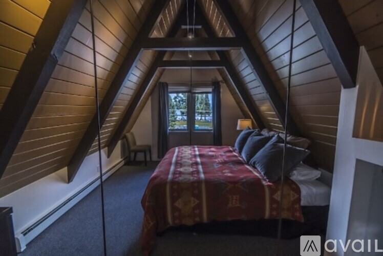 A bedroom with a bed in the middle of the room with a window behind it.