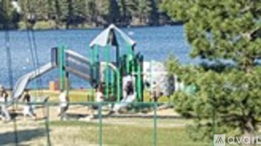 A playground with a green slide and a blue sky in the background.