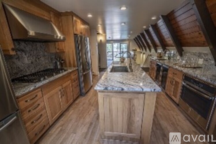 A kitchen with wooden cabinets and a marble countertop.
