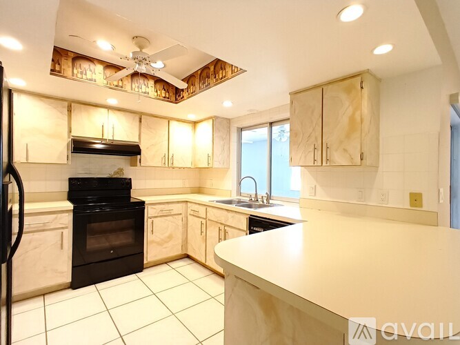 A kitchen with a black oven and wooden cabinets.