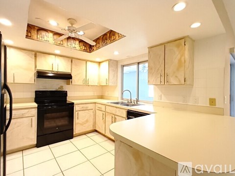 A kitchen with a black oven and wooden cabinets.