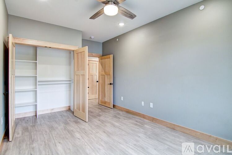 A room with a ceiling fan and light, and a wall with four switches.