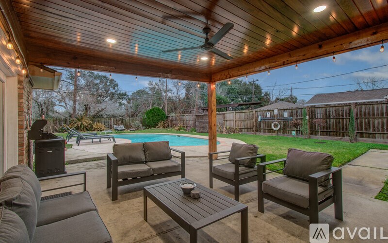 A patio with a table, chairs, and a pool.