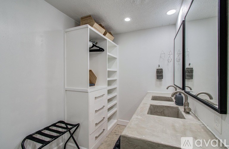 A bathroom with a sink, mirror, and a cabinet with drawers.