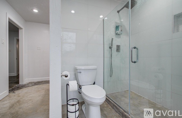 A white toilet in a bathroom with a glass shower door.