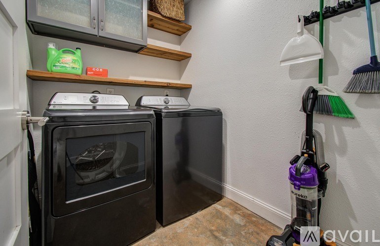 A black oven is in a kitchen with a vacuum cleaner to the side.