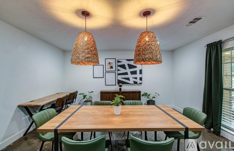 A dining room with a wooden table and green chairs.