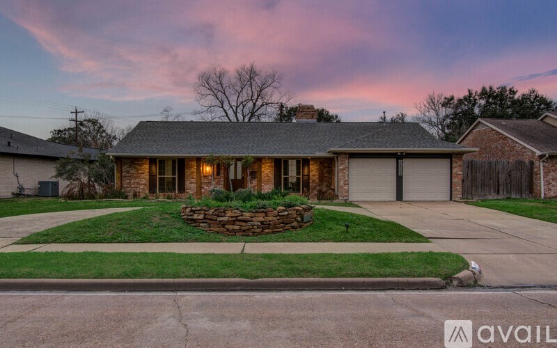 A house with a front yard and a stone wall.