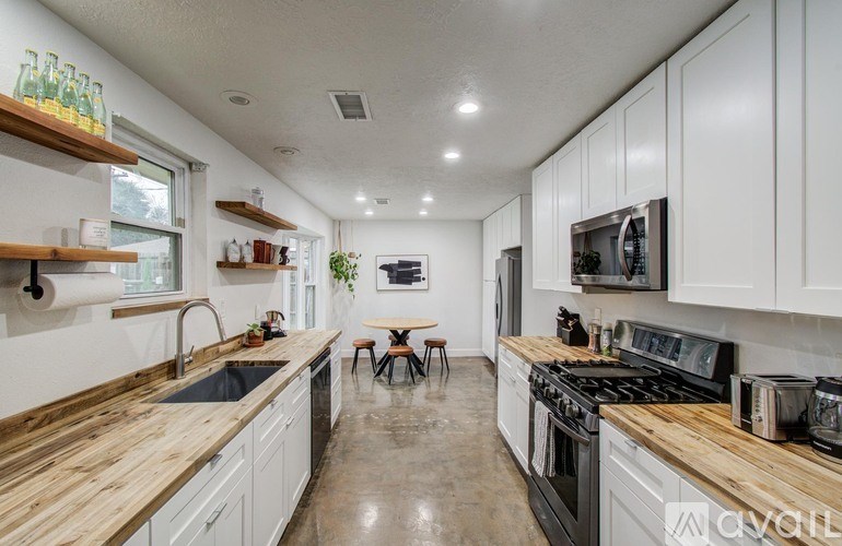 A kitchen with white cabinets and wooden countertops.