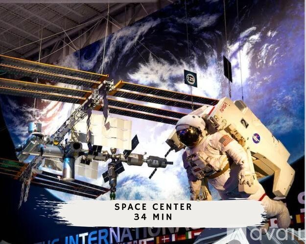 An astronaut in a space suit is standing in a space center with a backdrop of a space shuttle.