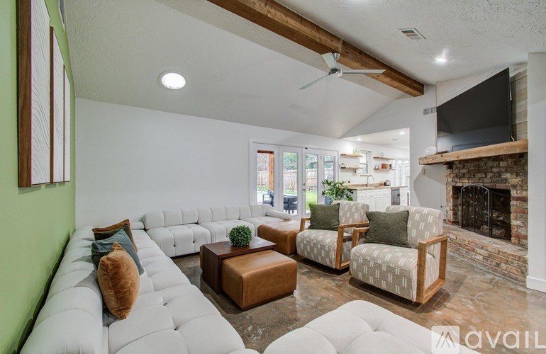 A living room with a white couch, a fireplace, and a television.