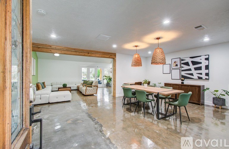A modern living room with a dining area and a kitchen in the background.