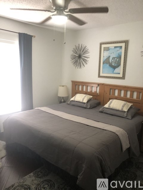 A bedroom with a bed, chair, and mirror.