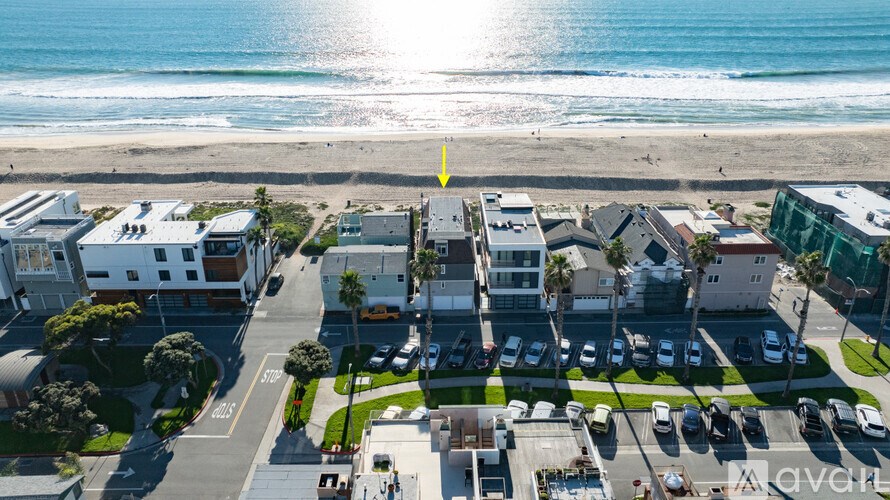 A beachfront street with cars parked on the side.