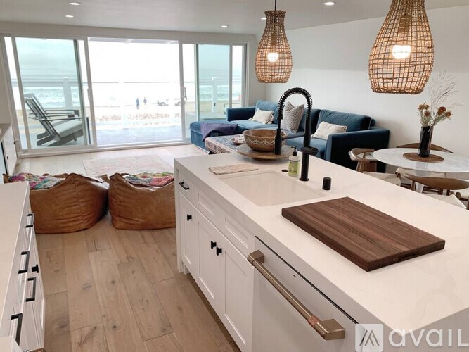 A kitchen with a large island and a view of the beach.