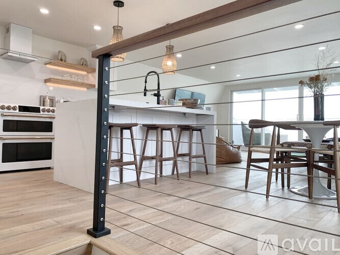 A modern kitchen with a white countertop and wooden flooring.