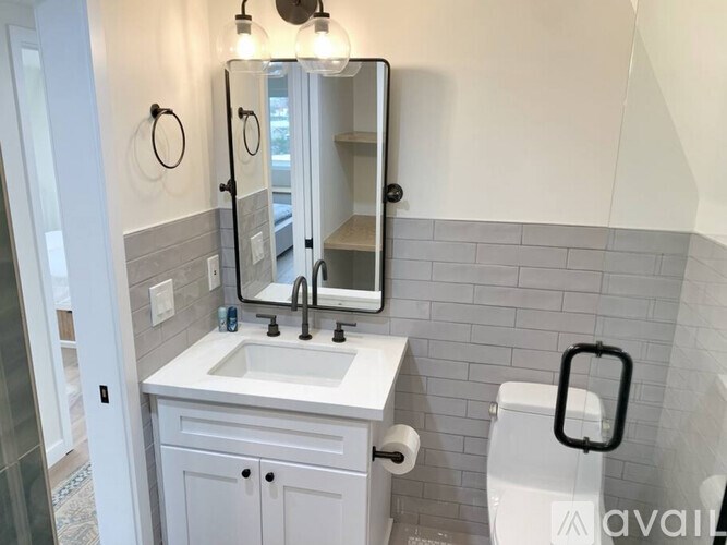 A bathroom with a white sink and a toilet paper roll on the counter.