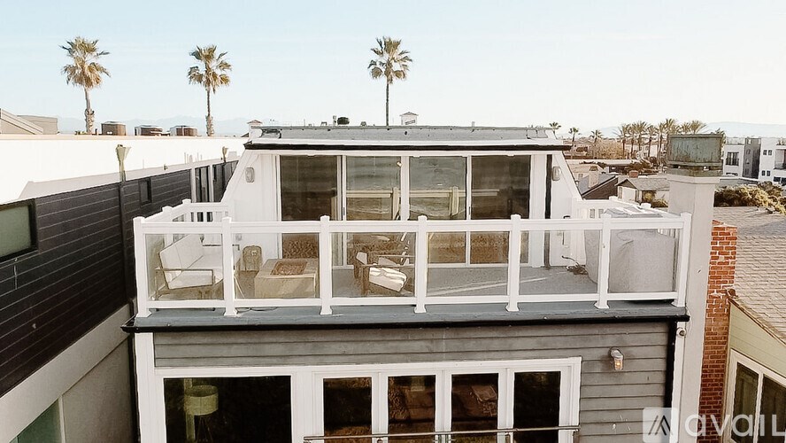 A balcony with a table and chairs overlooks a residential area.