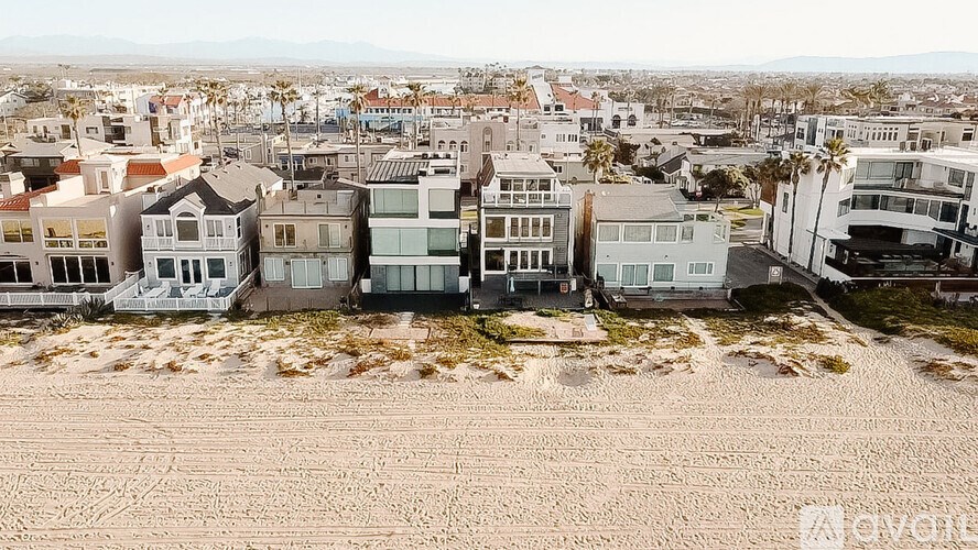 Beachfront houses with a sandy beach in front.