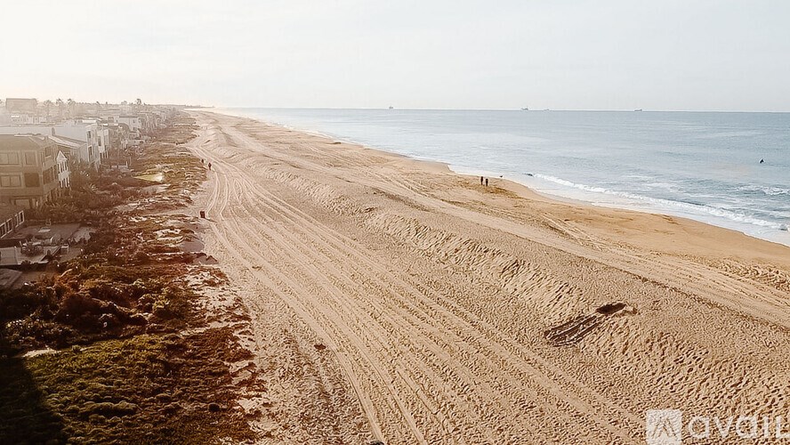 A beach with a car parked on the sand.