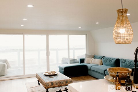 A living room with a blue couch and a wooden coffee table.